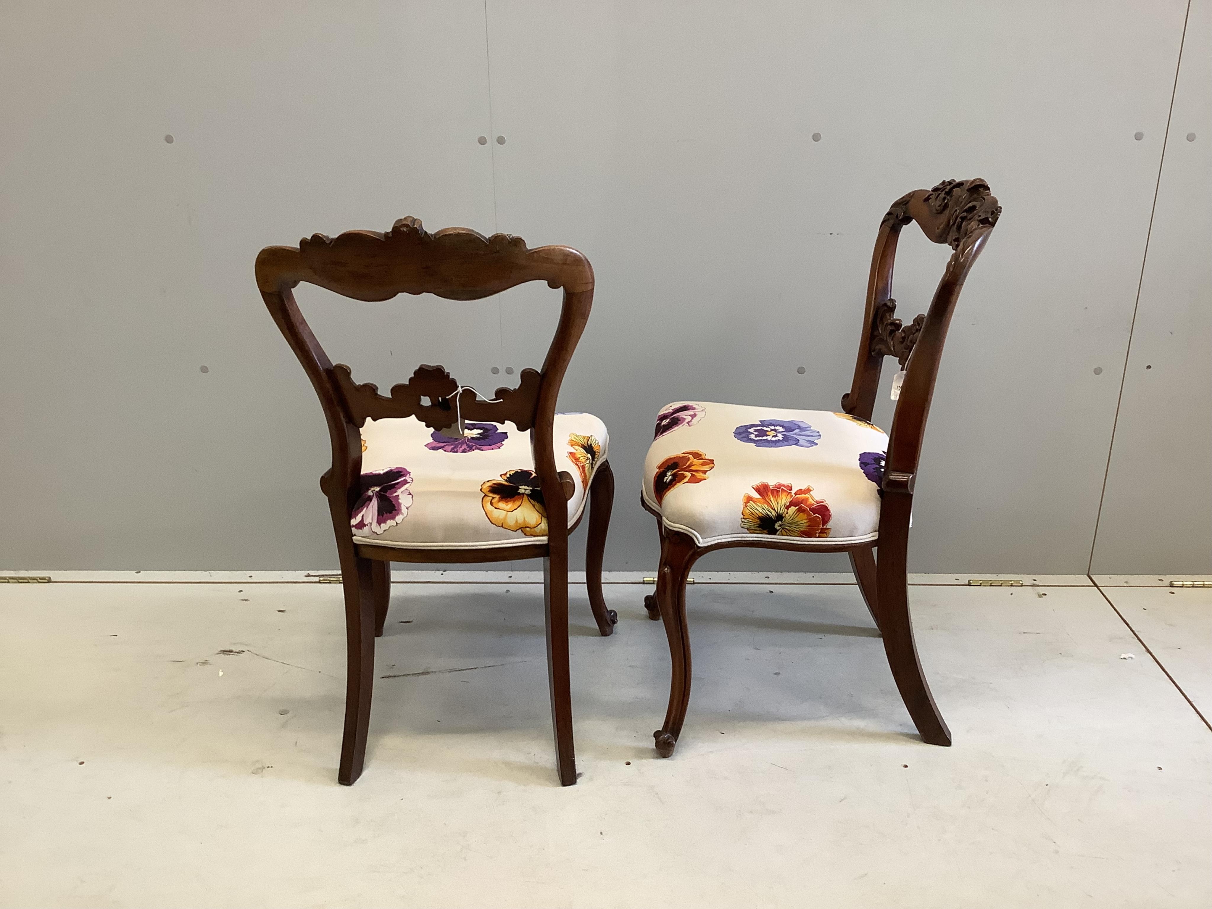 A pair of Victorian carved rosewood dining chairs, height 90cm. Condition - fair to good